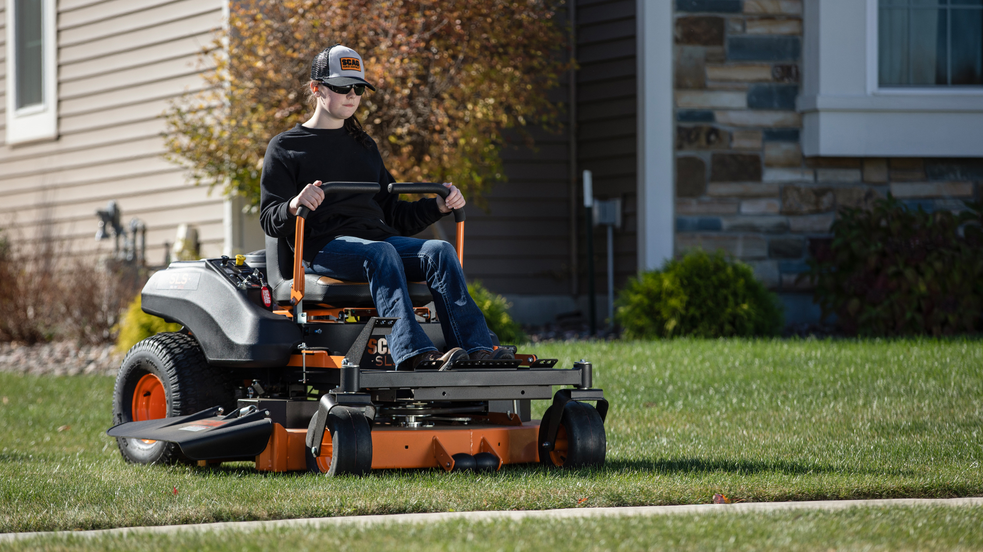 Woman operating a SLS mower in a yard