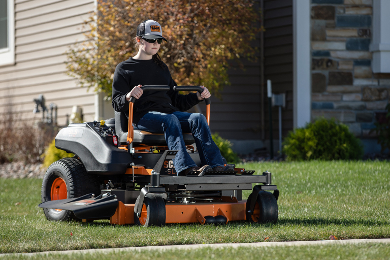 Woman operating a SLS mower in a yard